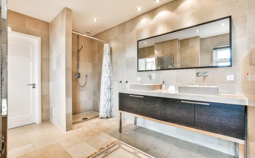 Aménagement épuré d'une rénovation salle de bain comprenant une baignoire blanche, une douche de tête intégrée et un long meuble vasque noir